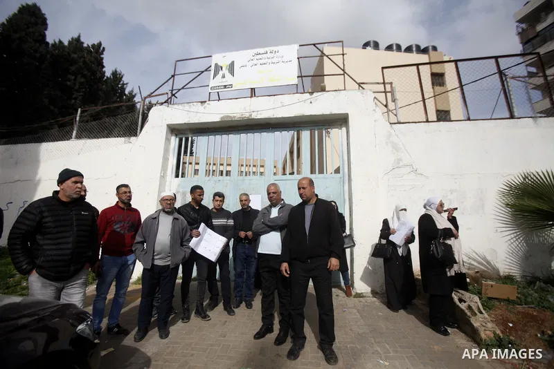 Palestinian teachers hold banners during a protest to demand their rights, in the West Bank city of Nablus on March 07, 2030. Photo by Mohammed Nasser\ apaimages