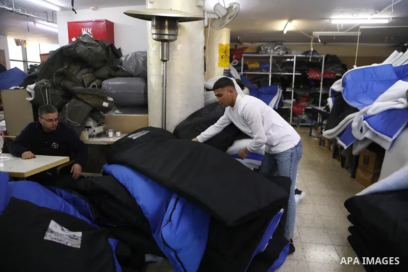 Palestinian employees work on an order of custom-made cold weather sleeping bags to be donated for earthquake relief, at the Palestinian Super-Tex al-Saafin textile factory in Hebron city in the West Bank on on February...