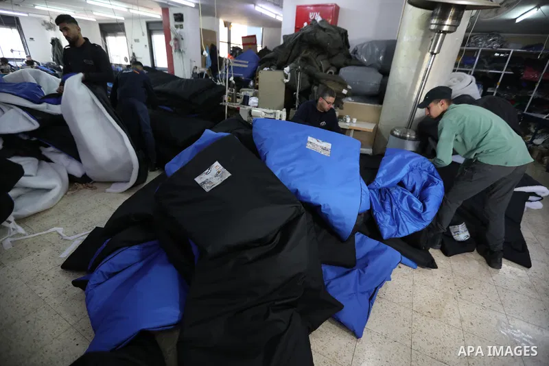 Palestinian employees work on an order of custom-made cold weather sleeping bags to be donated for earthquake relief, at the Palestinian Super-Tex al-Saafin textile factory in Hebron city in the West Bank on on February...