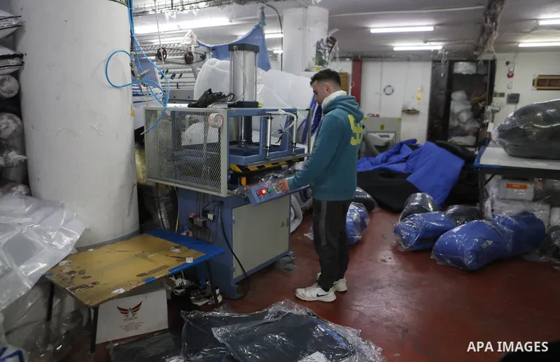 Palestinian employees work on an order of custom-made cold weather sleeping bags to be donated for earthquake relief, at the Palestinian Super-Tex al-Saafin textile factory in Hebron city in the West Bank on on February...