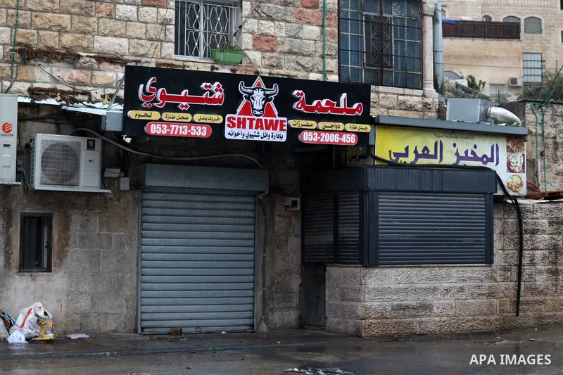 A Palestinian man walks past closed shops during a strike against house demolitions by Israeli authorities in the east Jerusalem neighbourhood of Jabal Mukaber on January 31, 2023. Photo by Ameer Abed Rabbo/APAimages