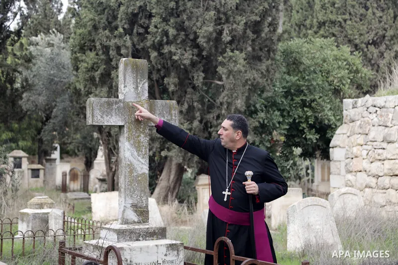 Hosam Naoum, archbishop and caretaker of the Protestant cemetery, inspects vandalised graves on Mount Zion outside Jerusalem's Old City on January 4, 2023. The Protestant Christian cemetery on Mount Zion in Jerusalem was...