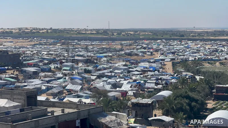 People sit near tents at a make-shift shelter for Palestinians who fled to Rafah in the southern Gaza Strip on February 08, 2024. Photo by Bashar Taleb\ apaimages