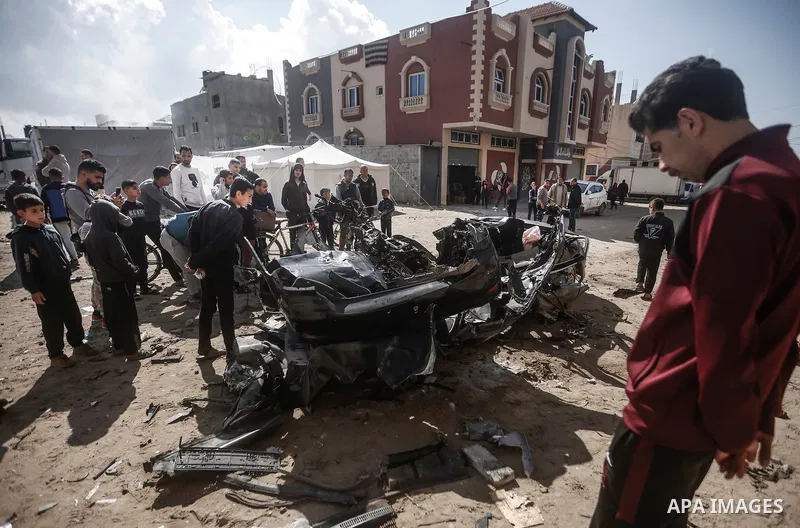 Palestinians inspect a destroyed car following the Israeli attacks in Rafah, Gaza on February 10, 2024. Photo by Bashar Taleb\ apaimages