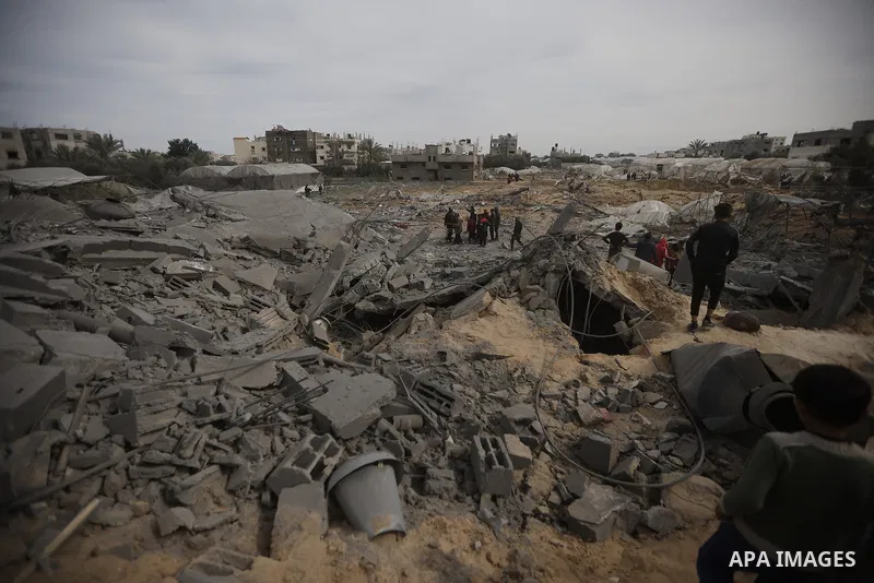 Palestinians inpect the damage in the rubble of a building where two hostages were reportedly held before being rescued during an operation by Israeli security forcess in Rafah, on the southern Gaza Strip on February 12,...