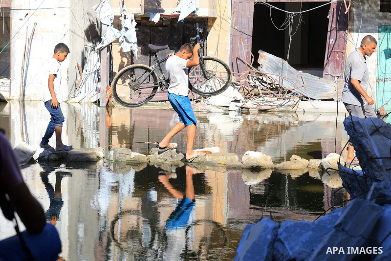 Sewage water is seen in the middle of a street between destroyed buildings in the southern Gaza Strip city of Khan Younis, on July 03, 2024. Health conditions in the Palestinian coastal enclave of Gaza Strip keep worseni...