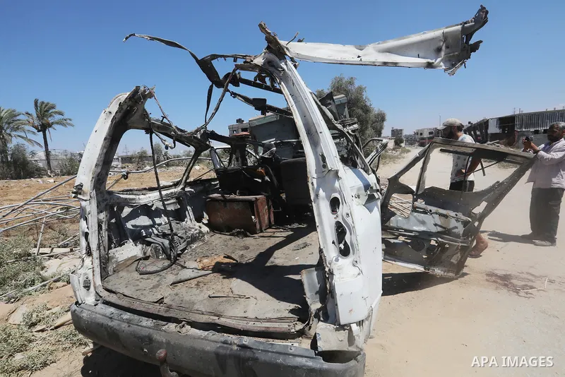 Palestinians inspect the destroyed vehicle after an Israeli attack in Al_Zawaida, Gaza on July 31, 2024. Deaths and injuries were reported after the attack at the location. Photo by Omar Ashtawy\ apaimages