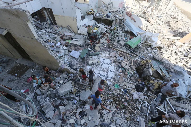 Palestinians inspect the site following the Israeli attack, in Al-Maghazi Refugee Cam, Gaza on August 14, 2024. The Israeli army attacked the building where the Eid family is located in the Al-Maghazi Refugee Camp in the...