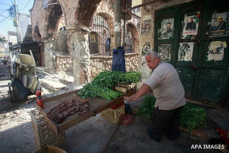 Palestinians walk past damage caused by Israeli army forces during a raid on the Balata refugee camp, near the West Bank city of Nablus, August 18, 2024. Photo by Mohammed Nasser\ apaimages