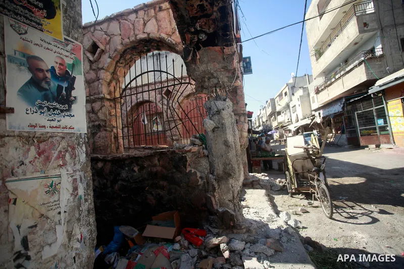 Palestinians walk past damage caused by Israeli army forces during a raid on the Balata refugee camp, near the West Bank city of Nablus, August 18, 2024. Photo by Mohammed Nasser\ apaimages