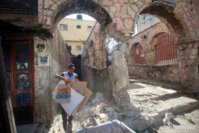 Palestinians walk past damage caused by Israeli army forces during a raid on the Balata refugee camp, near the West Bank city of Nablus, August 18, 2024. Photo by Mohammed Nasser\ apaimages