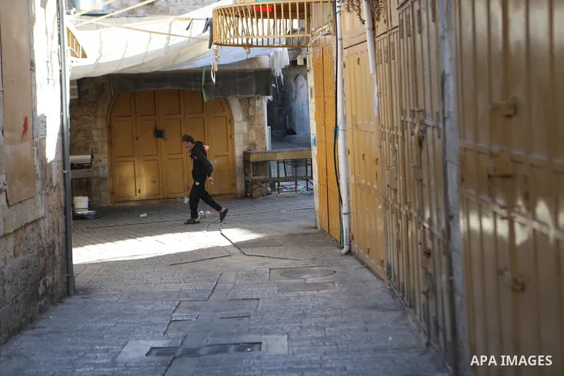 Palestinians walk past closed shops in the occupied West Bank city of Hebron after a call for a strike a day after an Israeli airstrike on the Tulkarm refugee camp reportedly killed 18 Palestinians, on October 4, 2024. P...