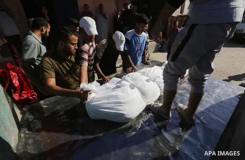 Relatives of the deceased mourn their bodies wrapped in shrouds after victims of an Israeli attack were transferred to Al-Aqsa Hospital in Deir al-Balah, Gaza Strip, on October 04, 2024. Photo by Omar Ashtawy\ apaimages