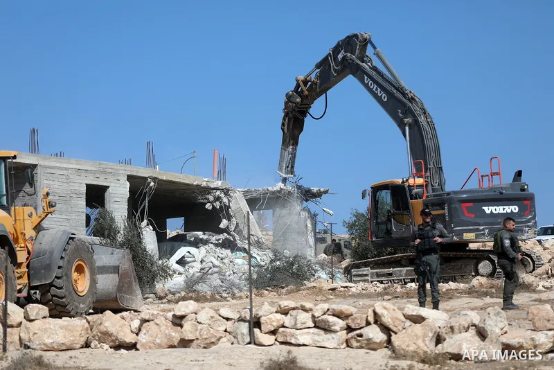 Israeli bulldozers under the supervision of the army, demolish two Palestinian houses in southern Yatta, south of Hebron, in the Israeli occupied West Bank on November 06, 2024. Israeli army forces demolished two houses...