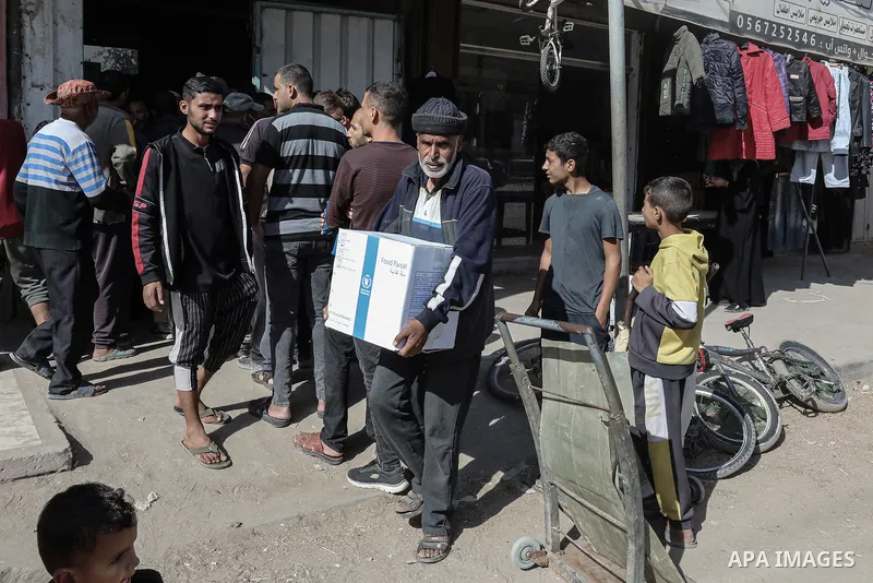 Palestinians transport boxs of humanitarian aid, supplied by the World Food Program, back to his home in Dair El-Balah in the central Gaza Strip on November 20, 2024, amid the ongoing war between Israel and the Hamas mil...