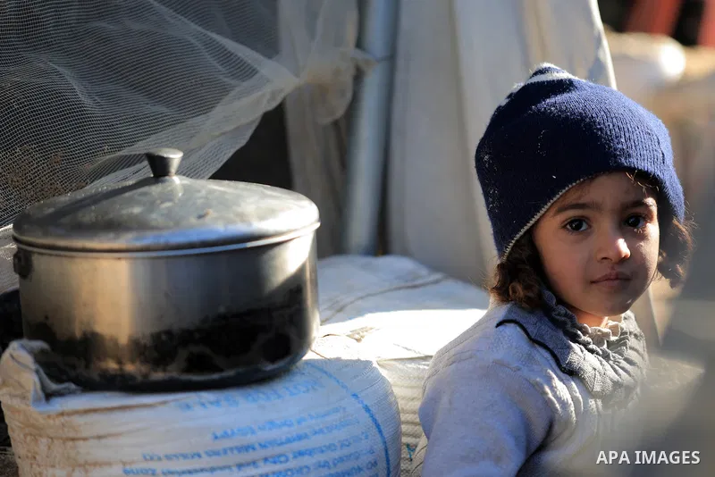 Palestinians, including children, who escaped from the attacks of the Israeli army and took shelter in the Khan Yunis, located in the south of the Gaza Strip and who are struggling with hunger wait in line to receive mea...