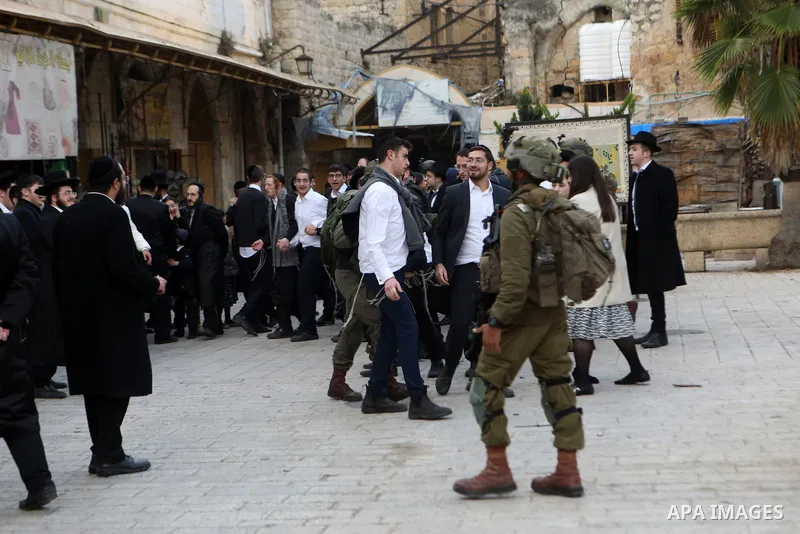 Israeli settlers escorted by Israeli forces participate in a provocative tour in Hebron city, West Bank on January 11, 2024. Photo by Mamoun Wazwaz\ apaimages