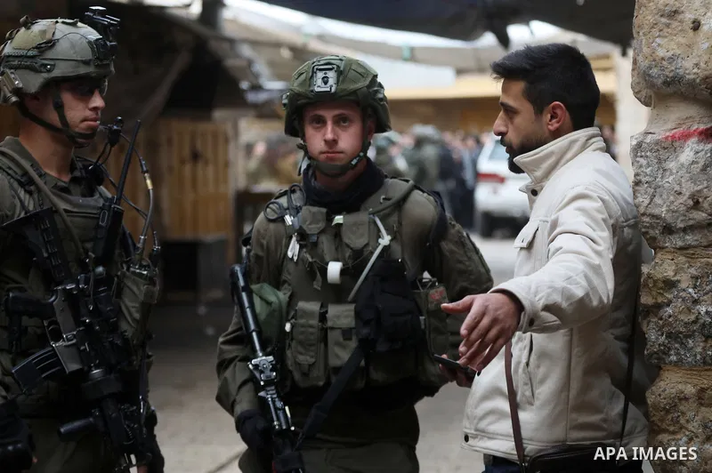 Israeli settlers escorted by Israeli forces participate in a provocative tour in Hebron city, West Bank on January 11, 2024. Photo by Mamoun Wazwaz\ apaimages
