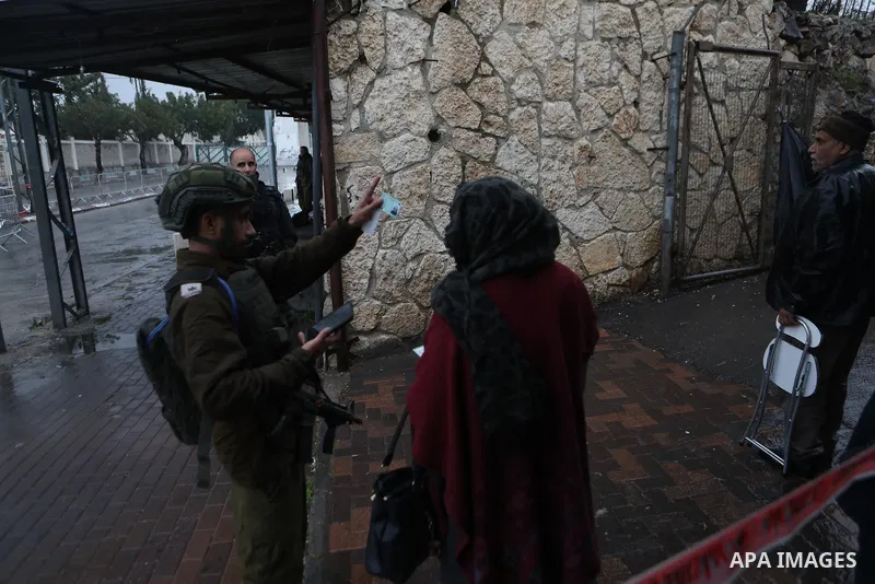 Palestinians walk through an Israeli checkpoint as they make their way to attend the first Friday prayers of the fasting month of Ramadan in Jerusalem's al-Aqsa mosque, in the West Bank city of Bethlehem, March 7, 2025....
