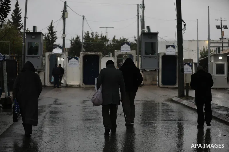 Palestinians walk through an Israeli checkpoint as they make their way to attend the first Friday prayers of the fasting month of Ramadan in Jerusalem's al-Aqsa mosque, in the West Bank city of Bethlehem, March 7, 2025....