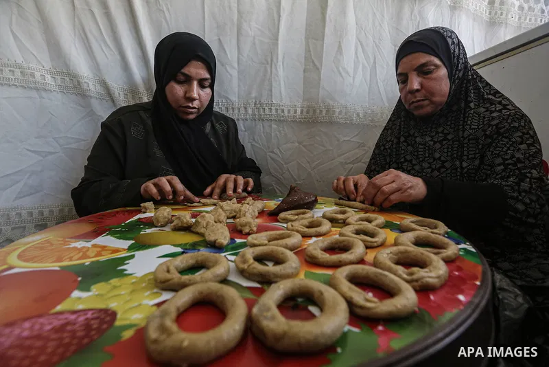 Palestinian families prepare the traditional cookies ahead of Eid al-Fitr, which marks the end of the holy fasting month of Ramadan, in Jabalia Palestinian refugee camp in the north of gaza Strip on March 27, 2025, amid...