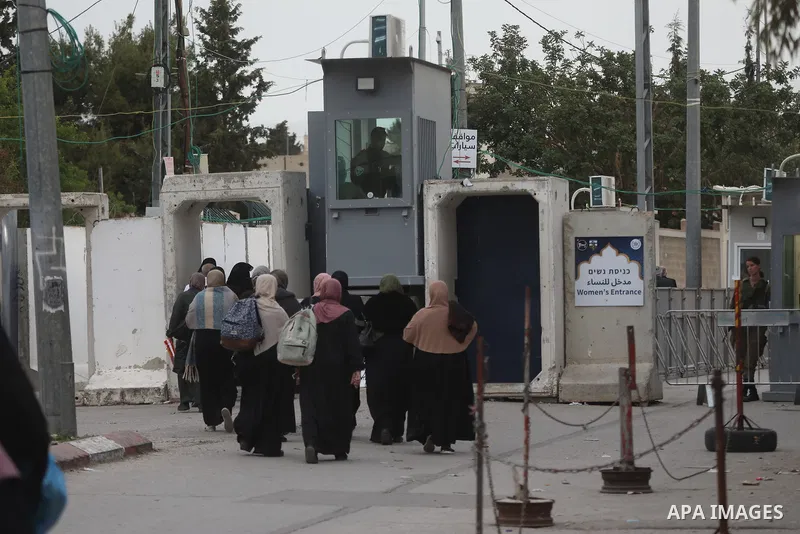Palestinians cross an Israeli army checkpoint in Bethlehem, in the occupied West Bank, on March 28, 2025, as Muslim worshippers head to the Al-Aqsa Mosque compound in Jerusalem's Old City for the last Friday prayers of t...