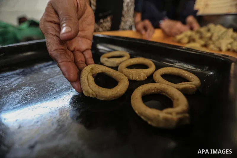 A Palestinian family prepares traditional cookies in preparation for Eid al-Fitr, which marks the end of the holy month of Ramadan, in the Shati refugee camp west of Gaza City on March 28, 2025, amid the ongoing Israeli...