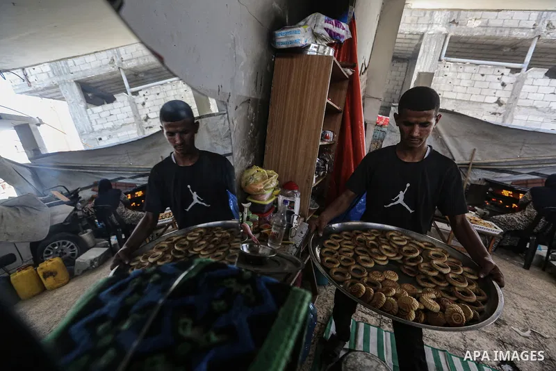 A Palestinian family prepares traditional cookies in preparation for Eid al-Fitr, which marks the end of the holy month of Ramadan, in the Shati refugee camp west of Gaza City on March 28, 2025, amid the ongoing Israeli...