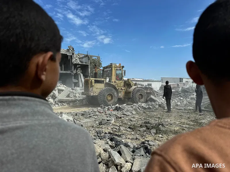 Palestinians inspect the site of an Israeli strike on tents and buildings site housing displaced people, in Khan Younis, in the southern Gaza Strip, April 13, 2025. Photo by Doaa el-Baz\ apaimages