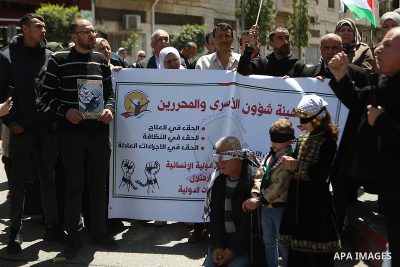 Demonstrators carry posters and portraits of Palestinian prisoners in Israeli jails during a gathering to commemorate Palestinian Prisoners' Day in the city of Hebron in the Israeli-occupied West Bank on April 17, 2025....