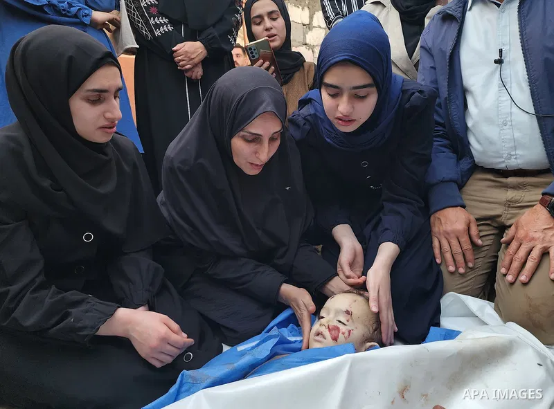 Relatives of Palestinian children, who lost their lives after Israeli attacks targeted Palestinians staying in houses and makeshift tents, mourn over the dead bodies of them following brought them to the morgue of the Na...