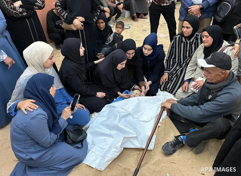 Relatives of Palestinian children, who lost their lives after Israeli attacks targeted Palestinians staying in houses and makeshift tents, mourn over the dead bodies of them following brought them to the morgue of the Na...