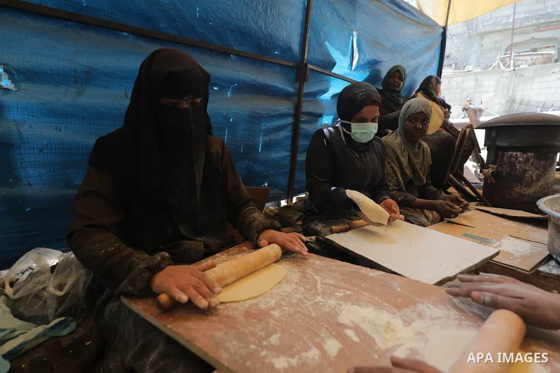 Palestinian women in the Gaza Strip are kneading and baking bread on a saj (traditional griddle) after two months of border crossings being closed by Israeli occupation forces, which has prevented the entry of aid—partic...