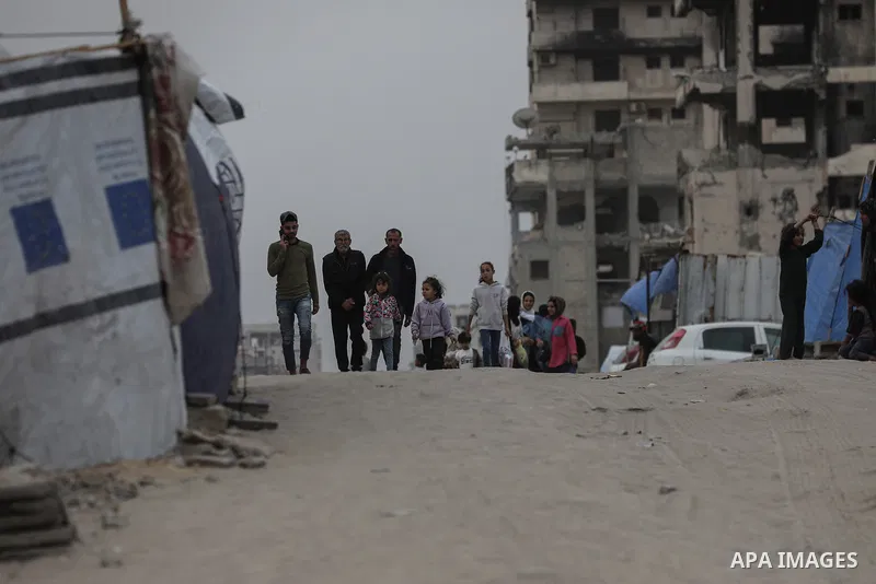 Palestinians walk amidst dust during a sand storm in Gaza City on April 30, 2025. The UN food agency, one of the main providers of food assistance in the besieged Palestinian territory said on April 25 it had "delivered...