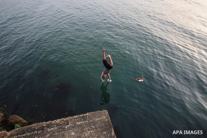 Palestinians, struggling with harsh living conditions due to ongoing Israeli attacks on the Gaza Strip and an intensifying heatwave, gather on the coast to cool off, spending the evening hours by the seaside to escape th...