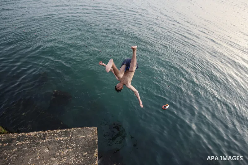 Palestinians, struggling with harsh living conditions due to ongoing Israeli attacks on the Gaza Strip and an intensifying heatwave, gather on the coast to cool off, spending the evening hours by the seaside to escape th...