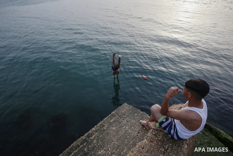 Palestinians, struggling with harsh living conditions due to ongoing Israeli attacks on the Gaza Strip and an intensifying heatwave, gather on the coast to cool off, spending the evening hours by the seaside to escape th...