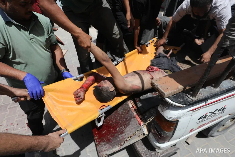 Plestinians transport the wounded and those who lost their lives incloud childern to Al-Awda Hospital after an Israeli bombing on school sheltering displaced people in the Nuseirat camp in the central Gaza Strip, on May...