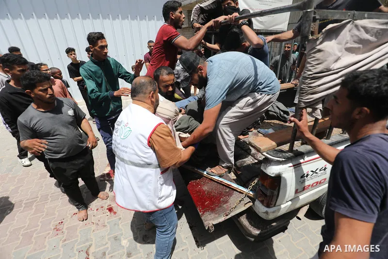 Plestinians transport the wounded and those who lost their lives incloud childern to Al-Awda Hospital after an Israeli bombing on school sheltering displaced people in the Nuseirat camp in the central Gaza Strip, on May...