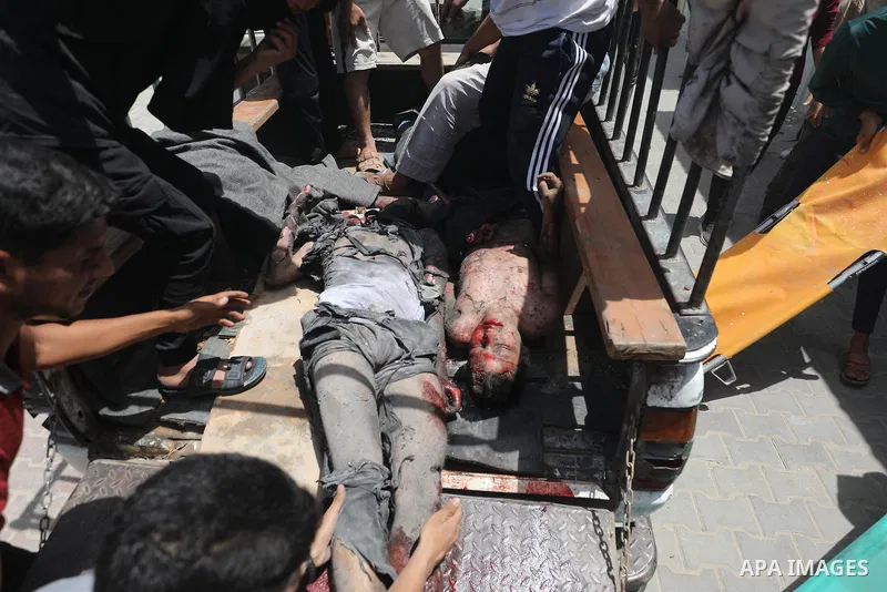 Plestinians transport the wounded and those who lost their lives incloud childern to Al-Awda Hospital after an Israeli bombing on school sheltering displaced people in the Nuseirat camp in the central Gaza Strip, on May...