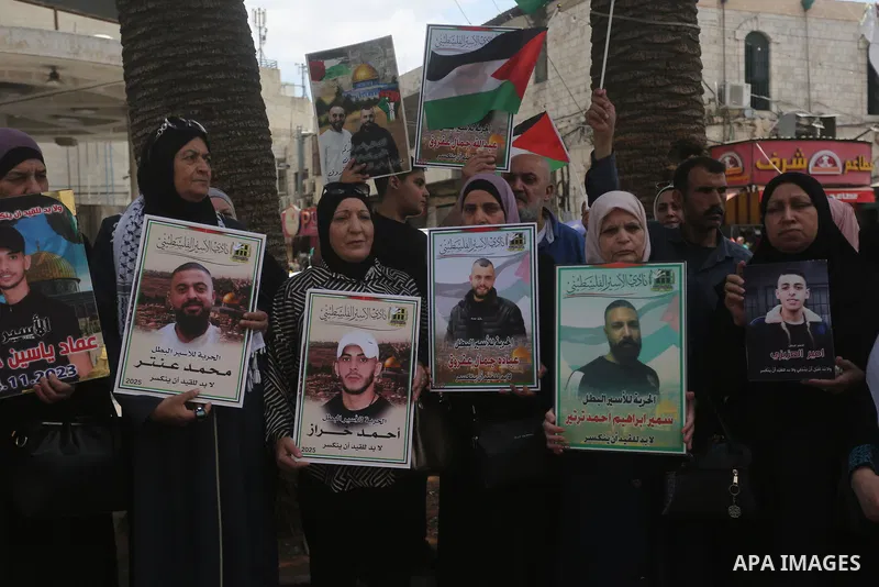 Palestinians protesters hold pictures of their relatives detained in Israeli prisons and wave Palestinian flags during a demonstration in solidarity with prisoners held in Israeli jails in the center of Nablus in the Wes...