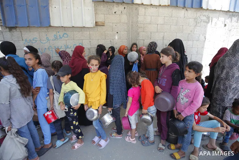 Internally displaced Palestinians gather in a charity kitchen to receive limited rations amid a shortage of food, in Nuseirat Palestinian refugee camp, central of Gaza Strip, June 7, 2025. The United Nations has warned t...