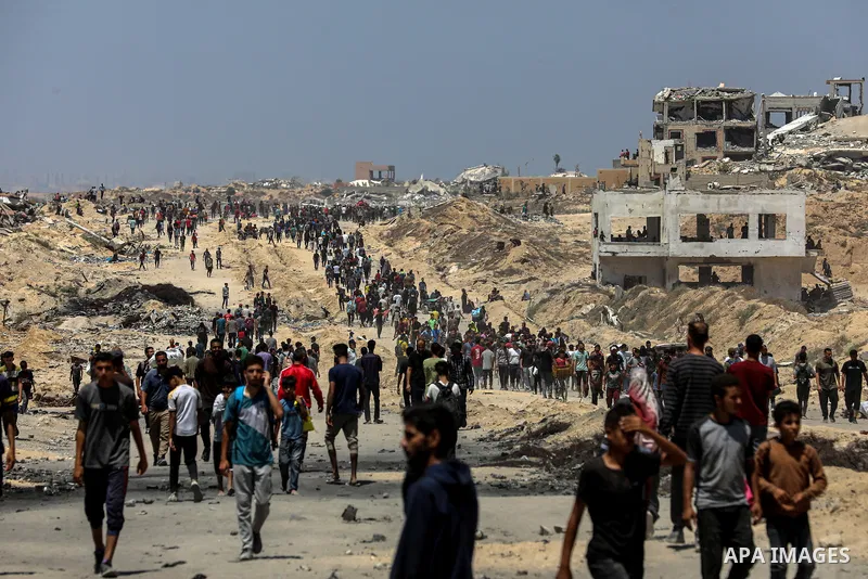 Palestinians gather along the Coastal Road in the Al-Sudaniyya area in northern Gaza as they wait to receive humanitarian aid expected to enter through the Zikim crossing, on June 12, 2025 in Gaza. Long queues formed as...