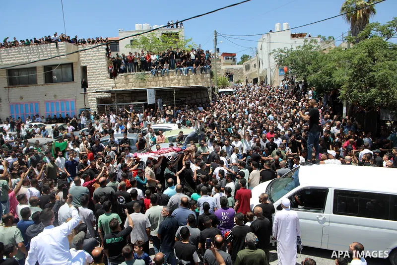 Palestinian mourners carry the body of Mohammed Ahmed Al-Hour, who was killed the day before during clashes with Israeli settlers, during his funeral in the village of Surif, north of Hebron in the occupied West Bank on...