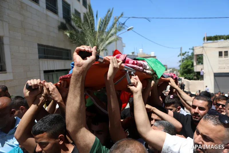 Palestinian mourners carry the body of Mohammed Ahmed Al-Hour, who was killed the day before during clashes with Israeli settlers, during his funeral in the village of Surif, north of Hebron in the occupied West Bank on...