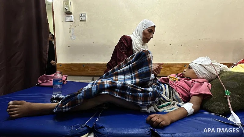 Palestinian child Mais Abdel Aal, 10 years old and displaced to the Al-Mawasi area west of Khan Younis, is receiving medical care at Nasser Medical Complex after being shot by a drone while inside the tent sheltering her...
