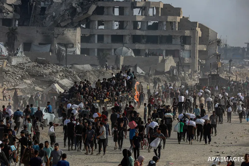 Displaced Palestinians carry relief packages along Rashid Street, west of Jabalia, 22 June 2025, after humanitarian aid trucks entered the northern Gaza Strip through the Israeli-controlled Zikim crossing, northwest of G...