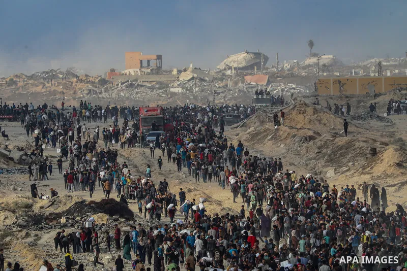 Displaced Palestinians carry relief packages along Rashid Street, west of Jabalia, 22 June 2025, after humanitarian aid trucks entered the northern Gaza Strip through the Israeli-controlled Zikim crossing, northwest of G...