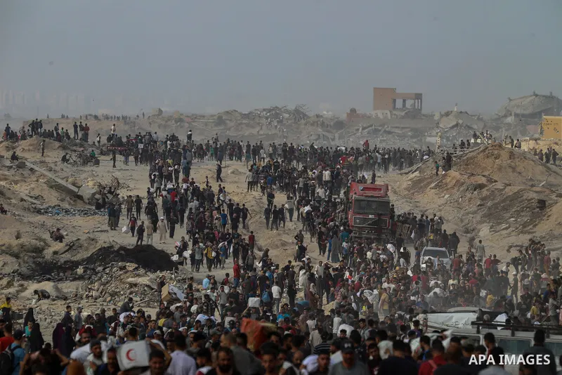 Displaced Palestinians carry relief packages along Rashid Street, west of Jabalia, 22 June 2025, after humanitarian aid trucks entered the northern Gaza Strip through the Israeli-controlled Zikim crossing, northwest of G...