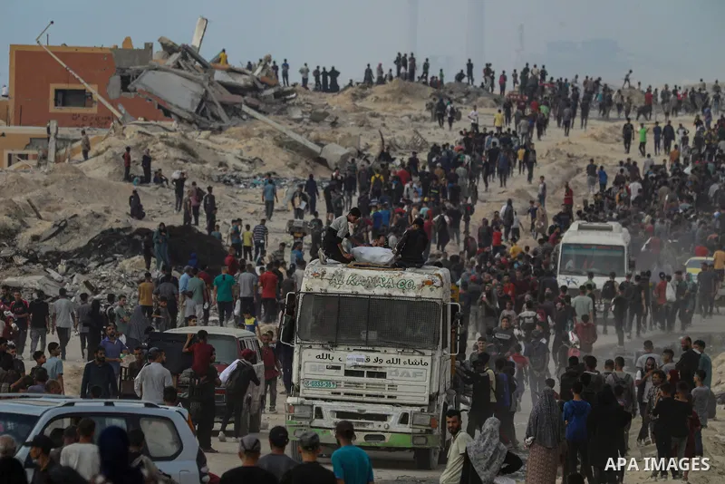 Displaced Palestinians carry relief packages along Rashid Street, west of Jabalia, 22 June 2025, after humanitarian aid trucks entered the northern Gaza Strip through the Israeli-controlled Zikim crossing, northwest of G...